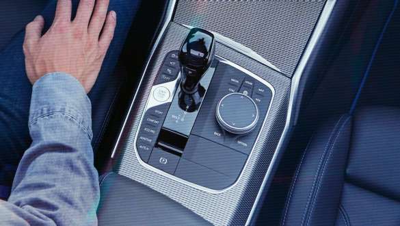 BMW 3. sērijas Sedan, Steptronic sporta pārnesumkārba. Detalizēts skats no putna lidojuma uz BMW 3. sērijas Sedan viduskonsoli ar pārnesumu pārslēgsviru un Steptronic sporta pārnesumkārbu.