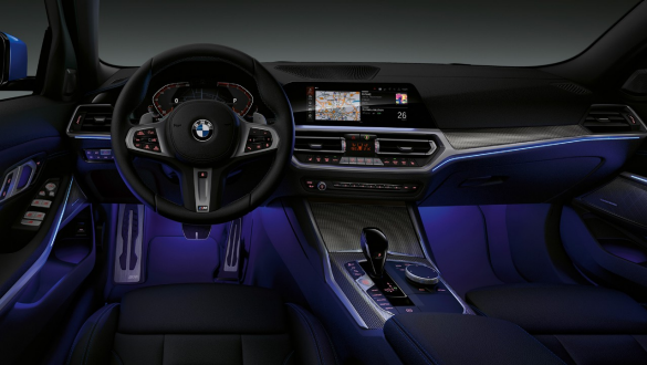 BMW 3. sērijas Sedan, fona apgaismojums Skats no priekšpuses uz BMW 3. sērijas Sedan vadītāja kokpitu, kurā vietu kājām izgaismo zils fona apgaismojums.