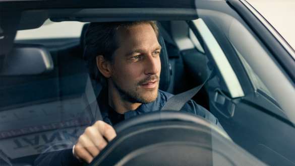 Vīrietis vada BMW Vīrietis vada BMW, skatoties cauri vējstiklam