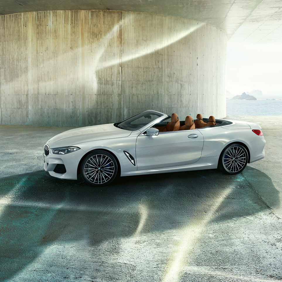 BMW M850i xDrive metāliskā Mineral White krāsā, sānskats ar atvērtu mīkstā seguma jumtu. BMW M850i xDrive metāliskā Mineral White krāsā, sānskats ar atvērtu mīkstā seguma jumtu.