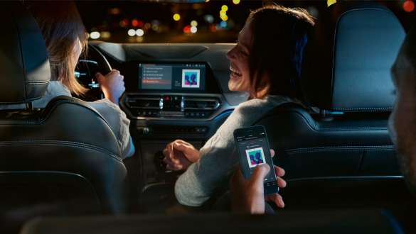 Vīrietis atver BMW ar digitālo atslēgu. BMW 8. sērijas Coupé, skats no sāna, vīrietis atver BMW ar digitālo atslēgu.