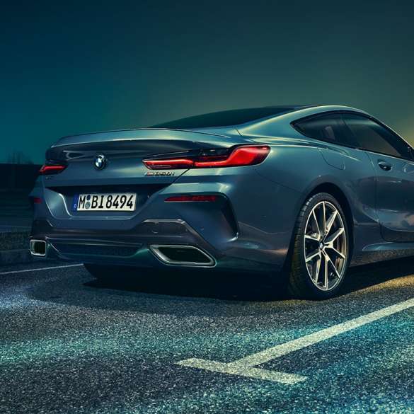BMW 8. sērijas Coupé, trīs ceturtdaļu aizmugures skats. BMW 8. sērijas Coupé, trīs ceturtdaļu aizmugures skats, stāvošs automobilis uz nakts ainavas fona.