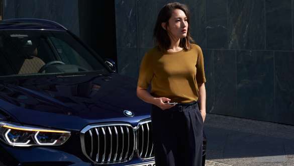 Vīrietis uz BMW fona BMW palīdzība uz ceļa, sieviete uz BMW fona