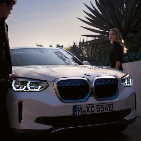 BMW iX3, G08 2020, trīs ceturtdaļu skats ar BMW i elipsveida režģi BMW iX3, G08 2020, metāliska Mineral White krāsa, trīs ceturtdaļu skats ar BMW i elipsveida režģi