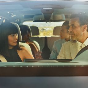 BMW žestu kontrole Vīrietis un sieviete sēž automobilī, sieviete izmanto žestu vadību