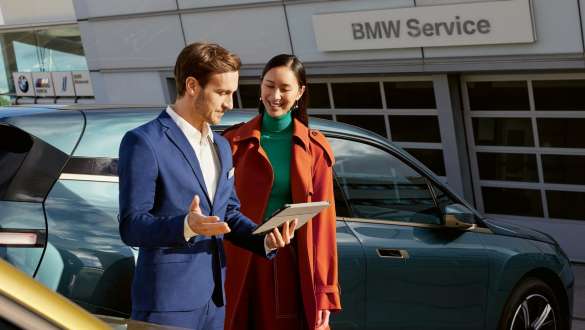 BMW Service Inclusive, vīrietis uz BMW i4 (G26) fona piekrastē BMW Service Inclusive, vīrietis uz BMW i4 (G26) fona piekrastē