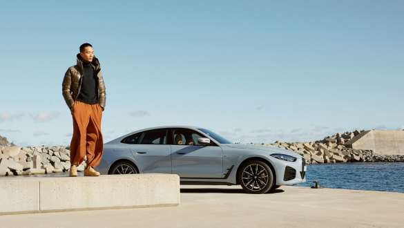 BMW riepu BMW serviss BMW serviss, vīrietis un sieviete uz BMW iX fona pie BMW servisa partnera