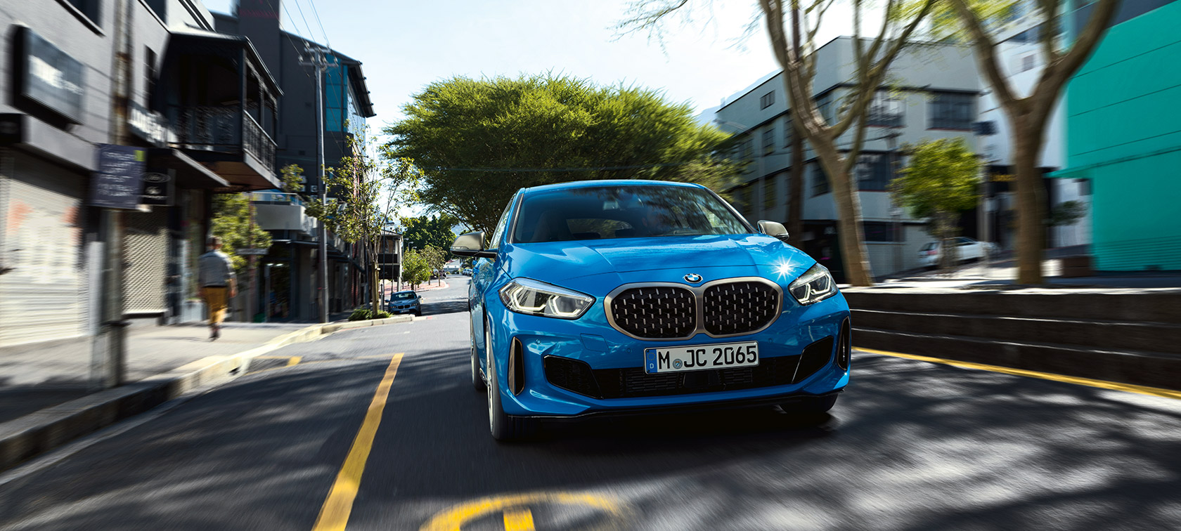 BMW 1. sērijas F40 metāliskā Misano Blue krāsā, braucošs automobilis no priekšpuses.