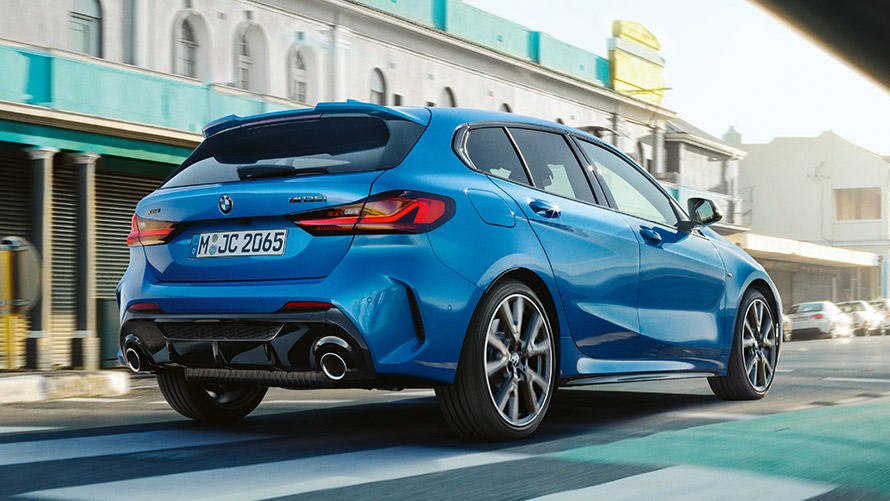 BMW 1. sērijas F40, trīs ceturtdaļu aizmugures skats, braucošs automobilis BMW 1. sērijas F40 metāliskā Misano Blue krāsā, trīs ceturtdaļu aizmugures skats, braucošs automobilis