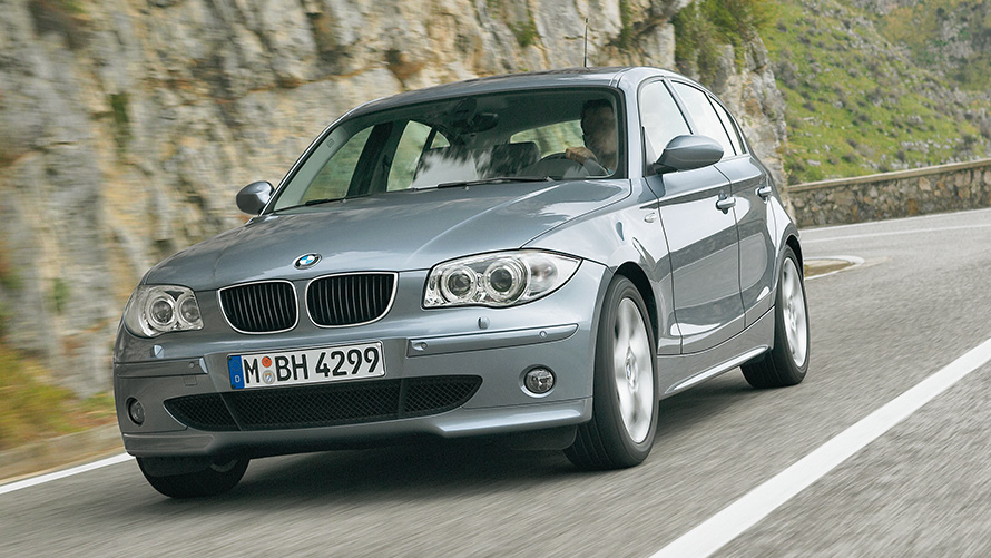BMW 1. sērija (E87), trīs ceturtdaļu priekšpuses skats, braucienā, uz pakalna fona BMW 1. sērija (E87), trīs ceturtdaļu priekšpuses skats, braucienā, uz pakalna fona