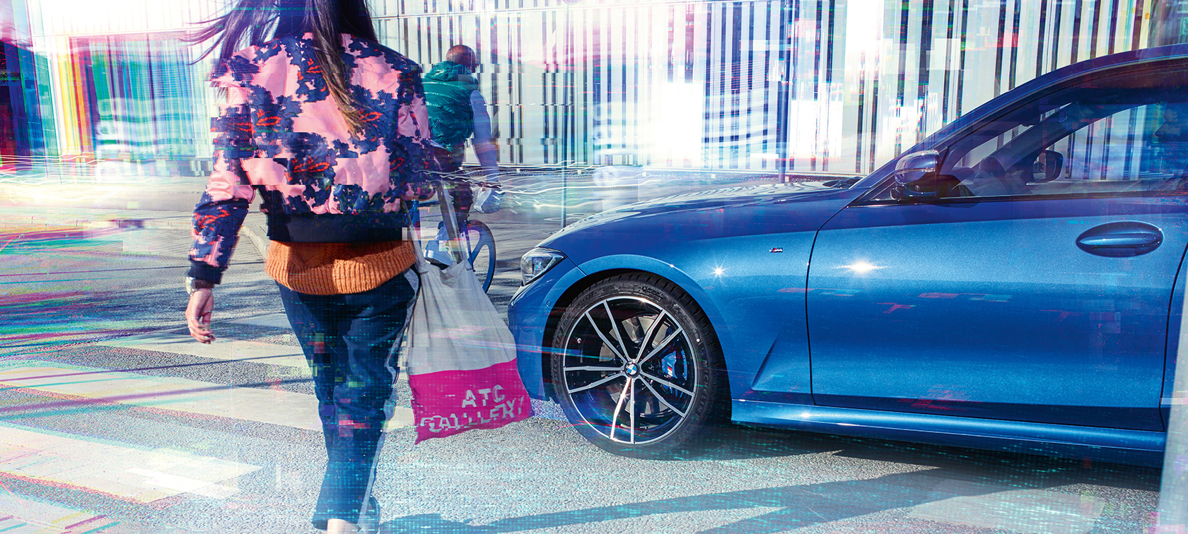 BMW 3. sērijas Sedan, trīs ceturtdaļu skats no sāna BMW 3. sērijas Sedan trīs ceturtdaļu skats no sāna braucienā pa asfaltu uz pilsētas fona.