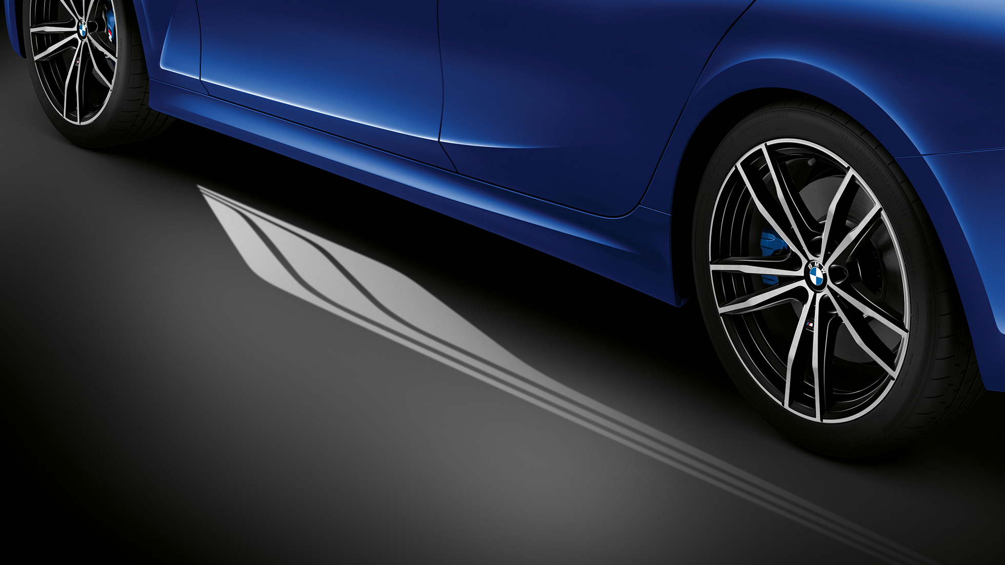 BMW 3. sērijas Sedan, fona apgaismojums Skats no priekšpuses uz BMW 3. sērijas Sedan vadītāja kokpitu, kurā vietu kājām izgaismo zils fona apgaismojums.