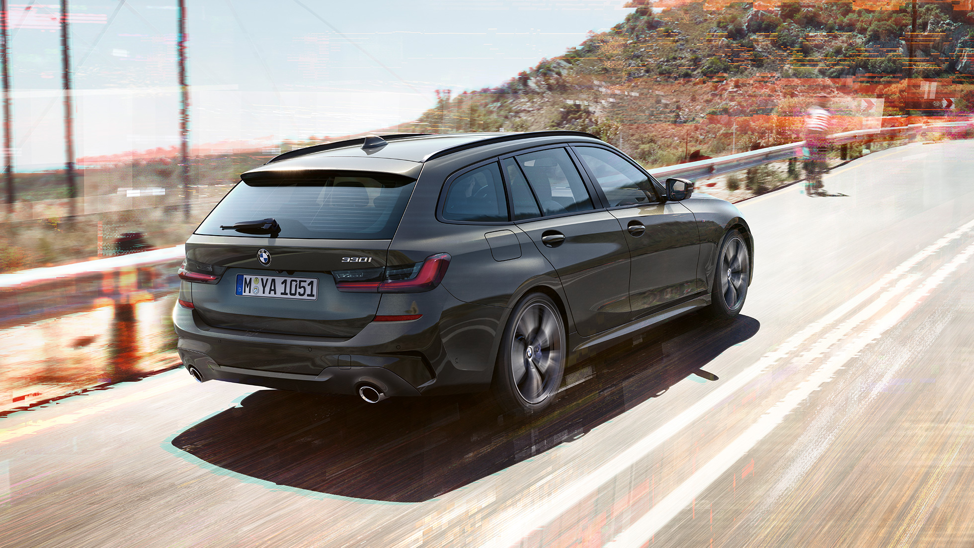 BMW 3. sērijas Touring, trīs ceturtdaļu aizmugures skats. BMW 3. sērijas Touring, trīs ceturtdaļu skats no aizmugures uz braucošu automobili uz tilta uz lauku apvidus fona