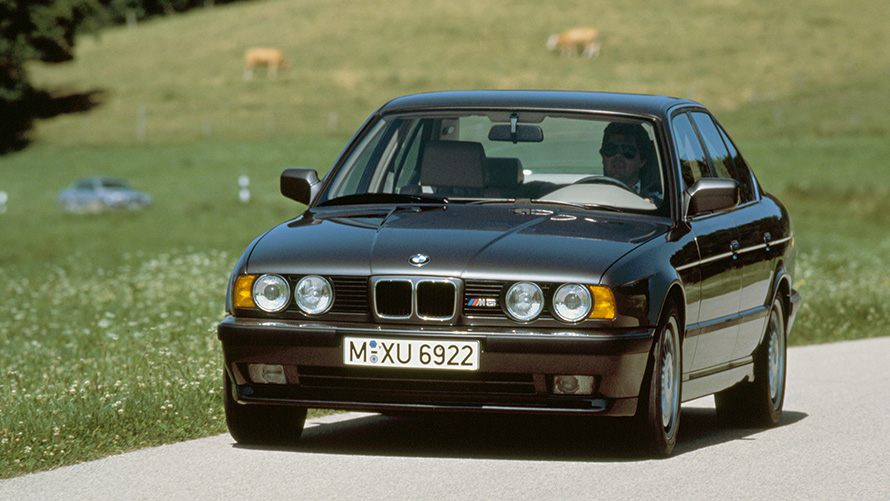 BMW M Sedan (E34), trīs ceturtdaļu priekšpuses skats, braucošs automobilis BMW M Sedan (E34), trīs ceturtdaļu priekšpuses skats, braucošs automobilis