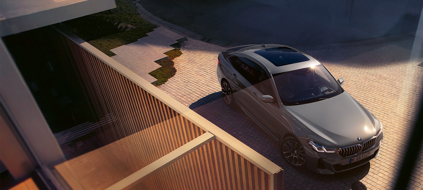 BMW 6. sērijas Gran Turismo 640i xDrive (G32), Bernina Grey krāsa BMW 6. sērijas Gran Turismo 640i xDrive (G32), 2020, Bernina Grey krāsā, trīs ceturtdaļu priekšpuses skats no paaugstinājuma, uz ēkas fona