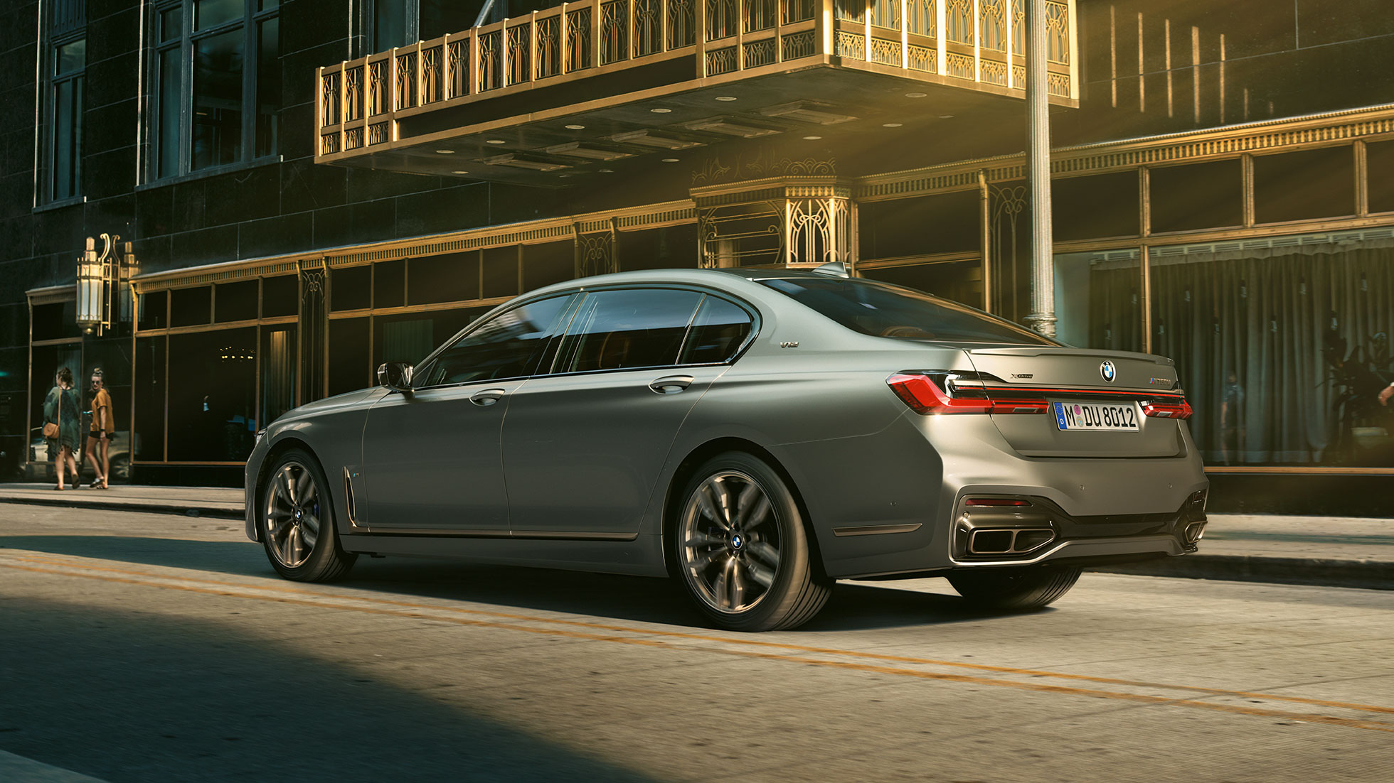BMW M760Li xDrive ar V12 dzinēju BMW M760Li xDrive novietots sāniski skatā no aizmugures uz debesskrāpju fona pilsētā