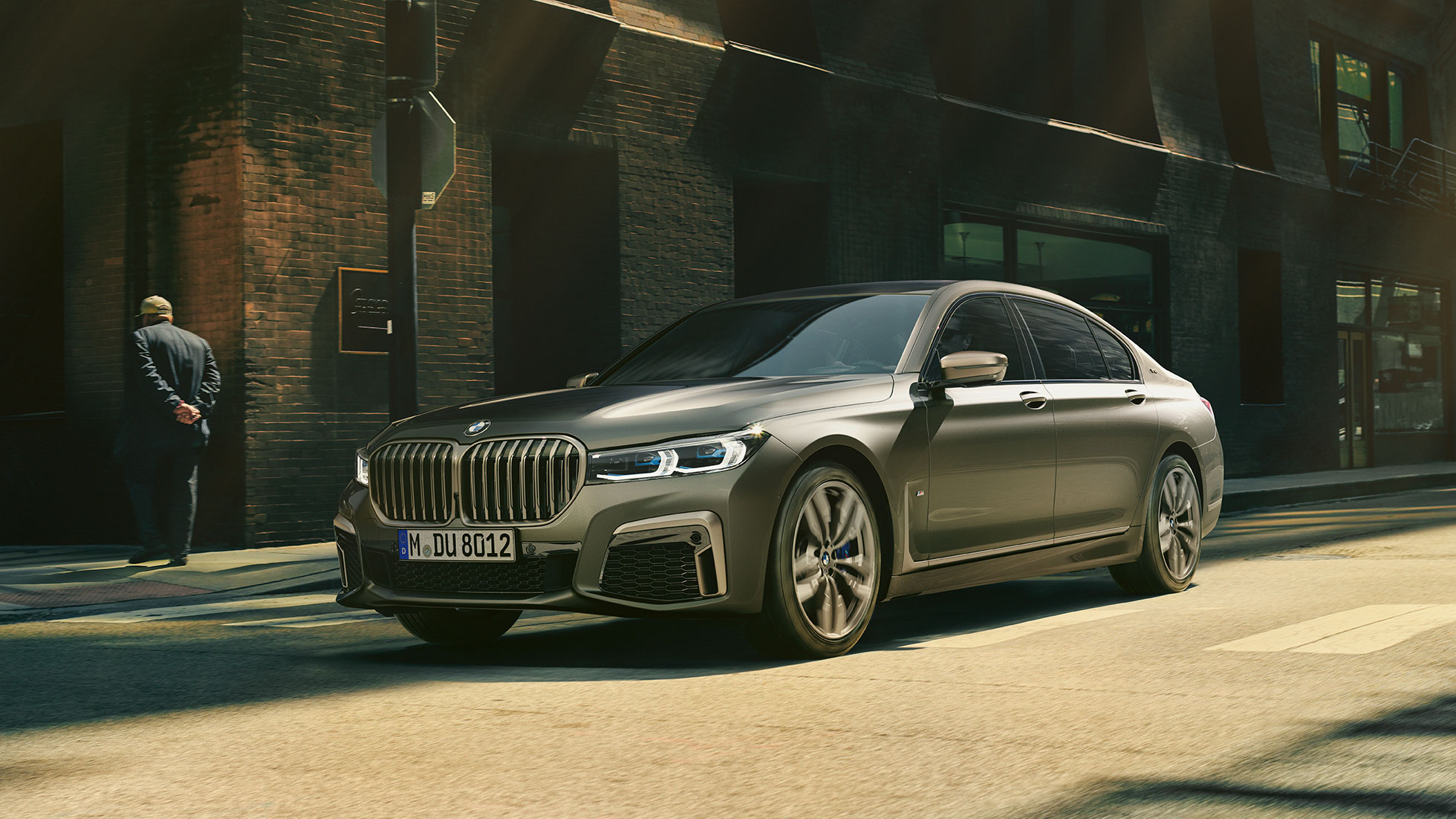 BMW M760Li xDrive pilsētā BMW M760Li xDrive sāniski skatā no priekšpuses, braucot pa ielu pilsētā