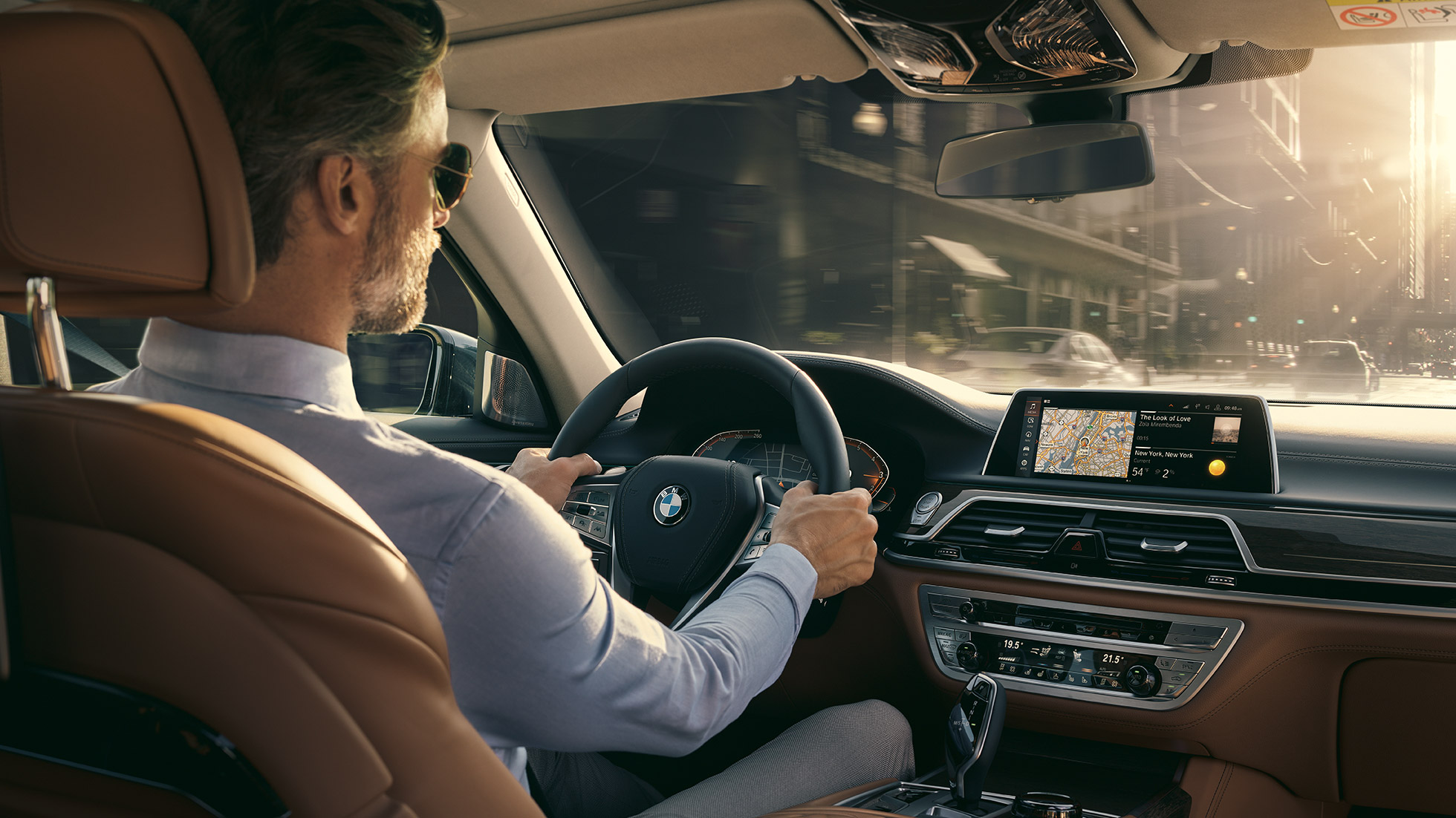 BMW 7. sērijas Sedan savienojamības funkcijas BMW 7. sērijas Sedan: vīrietis sēž BMW un izmanto savienojamības funkcijas