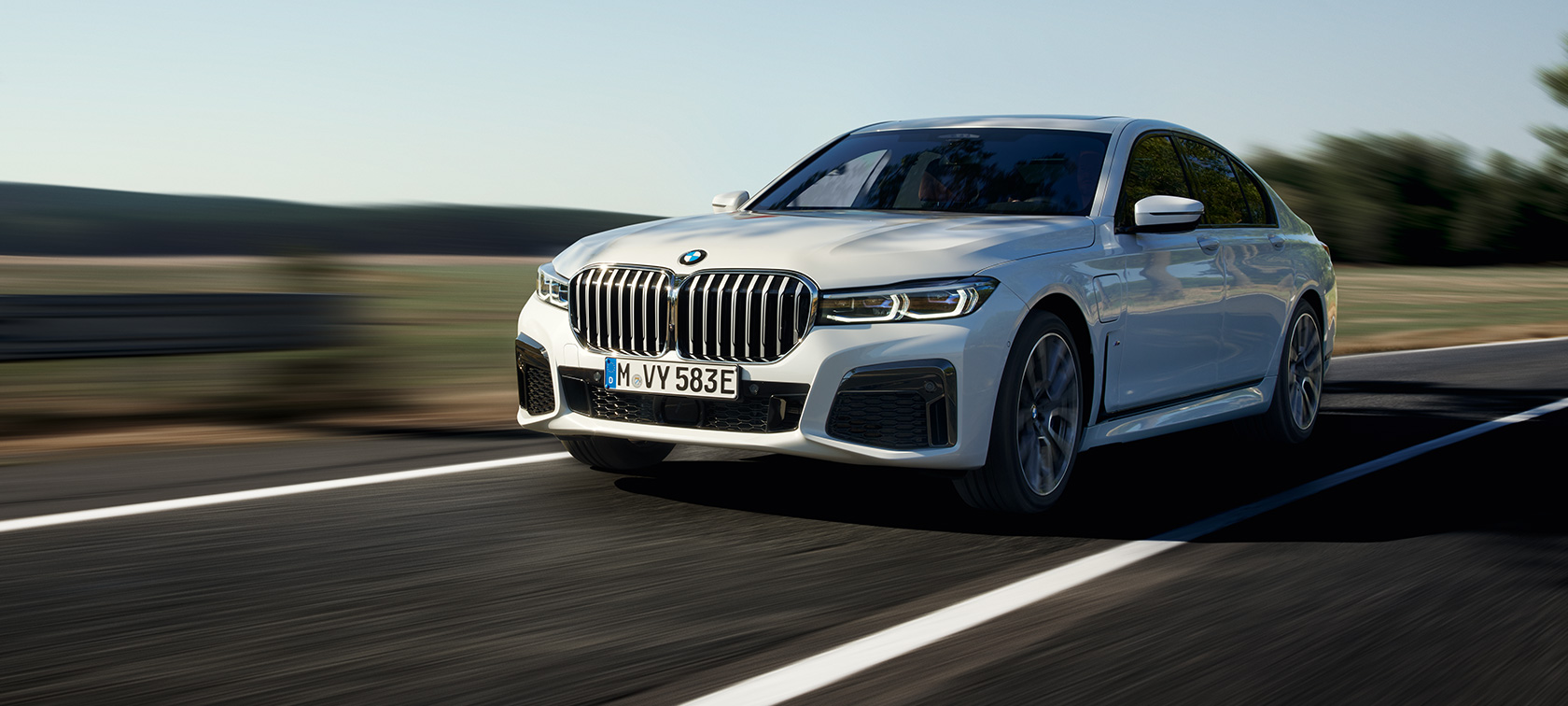 BMW 745e Sedan hibrīdauto G11, G12, Mineral White krāsa, trīs ceturtdaļu priekšpuses skats BMW 745e Sedan hibrīdauto G11, G12, metāliska Mineral White krāsa, trīs ceturtdaļu priekšpuses skats, pa lauku ceļu braucošs automobilis