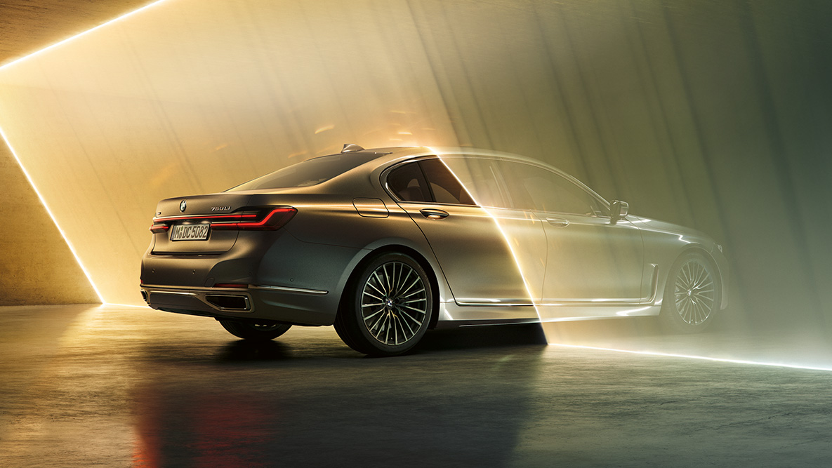 BMW 7. sērijas Sedan, G11, G12, 2019, Bernina Grey BMW 7. sērijas Sedan G11, G12, 2019, Bernina Grey Amber Effect krāsā trīs ceturtdaļu skatā no aizmugures, gaismas staru ieskauts