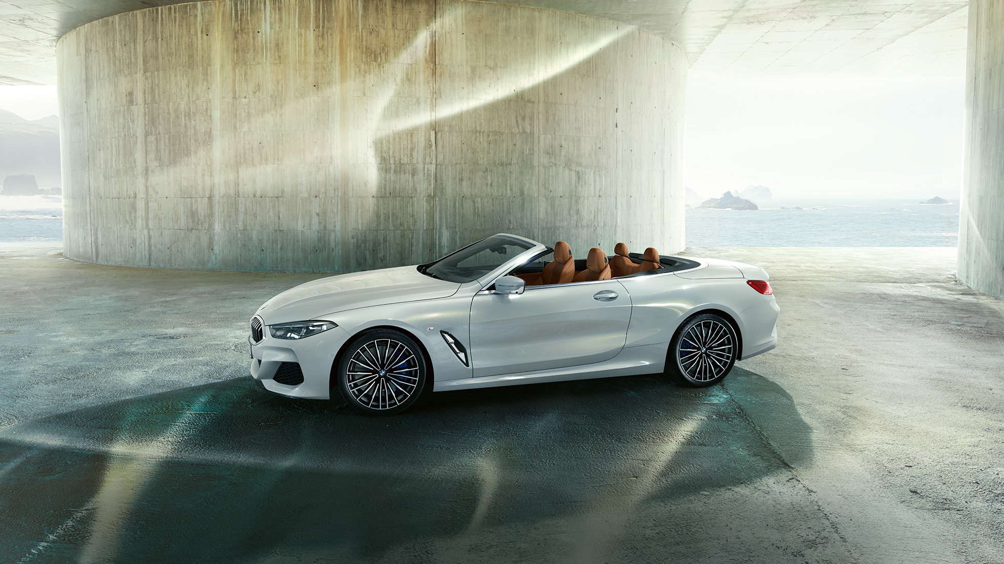 BMW M850i xDrive metāliskā Mineral White krāsā, sānskats ar atvērtu mīkstā seguma jumtu. BMW M850i xDrive metāliskā Mineral White krāsā, sānskats ar atvērtu mīkstā seguma jumtu.