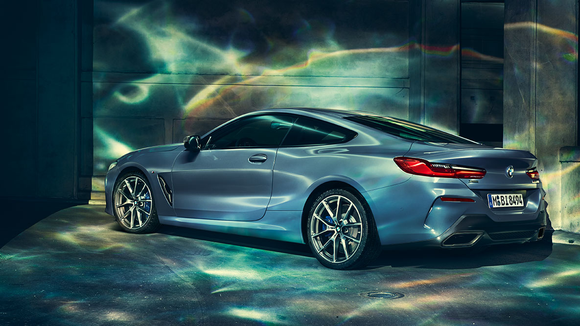 BMW 8. sērijas Coupé, trīs ceturtdaļu aizmugures skats. Trīs ceturtdaļu aizmugures skats uz BMW 8. sērijas Coupé uz pilsētas fona.