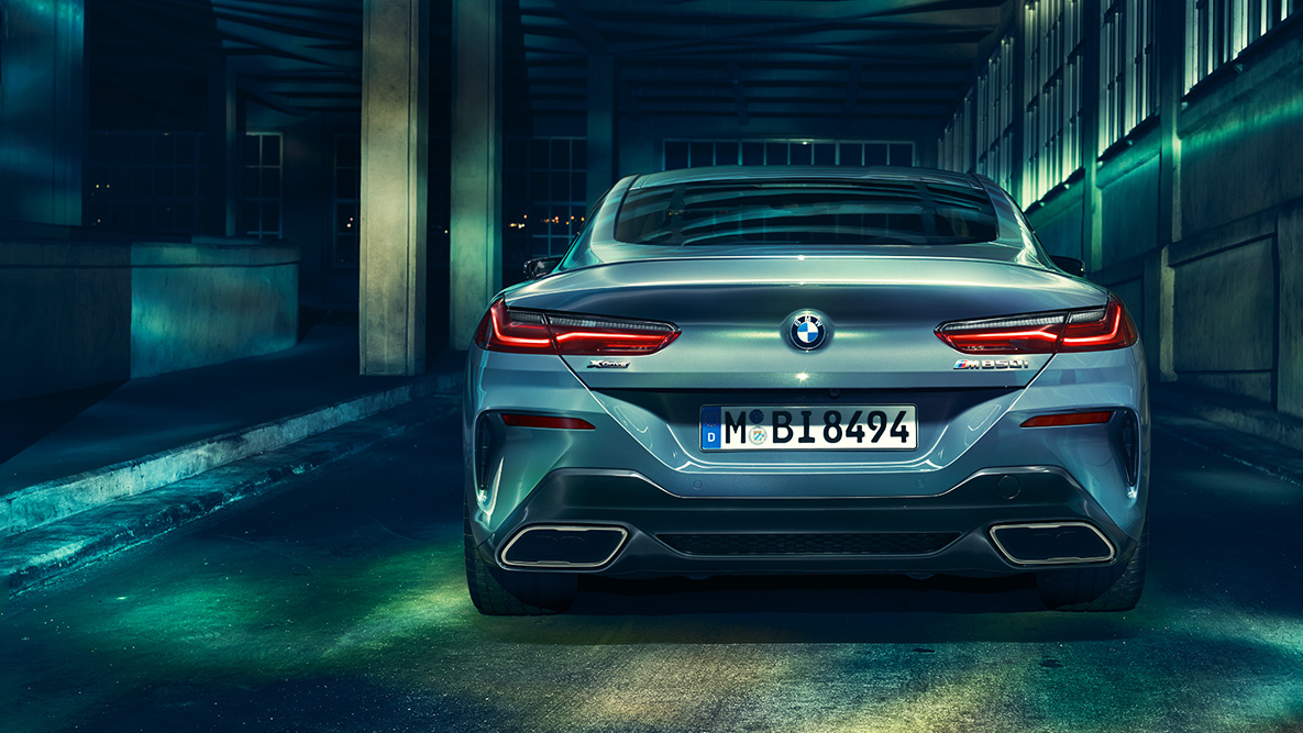 BMW 8.sērijas Coupé, aizmugures skats. BMW 8. sērijas Coupé aizmugures skats naksnīgā pilsētā.