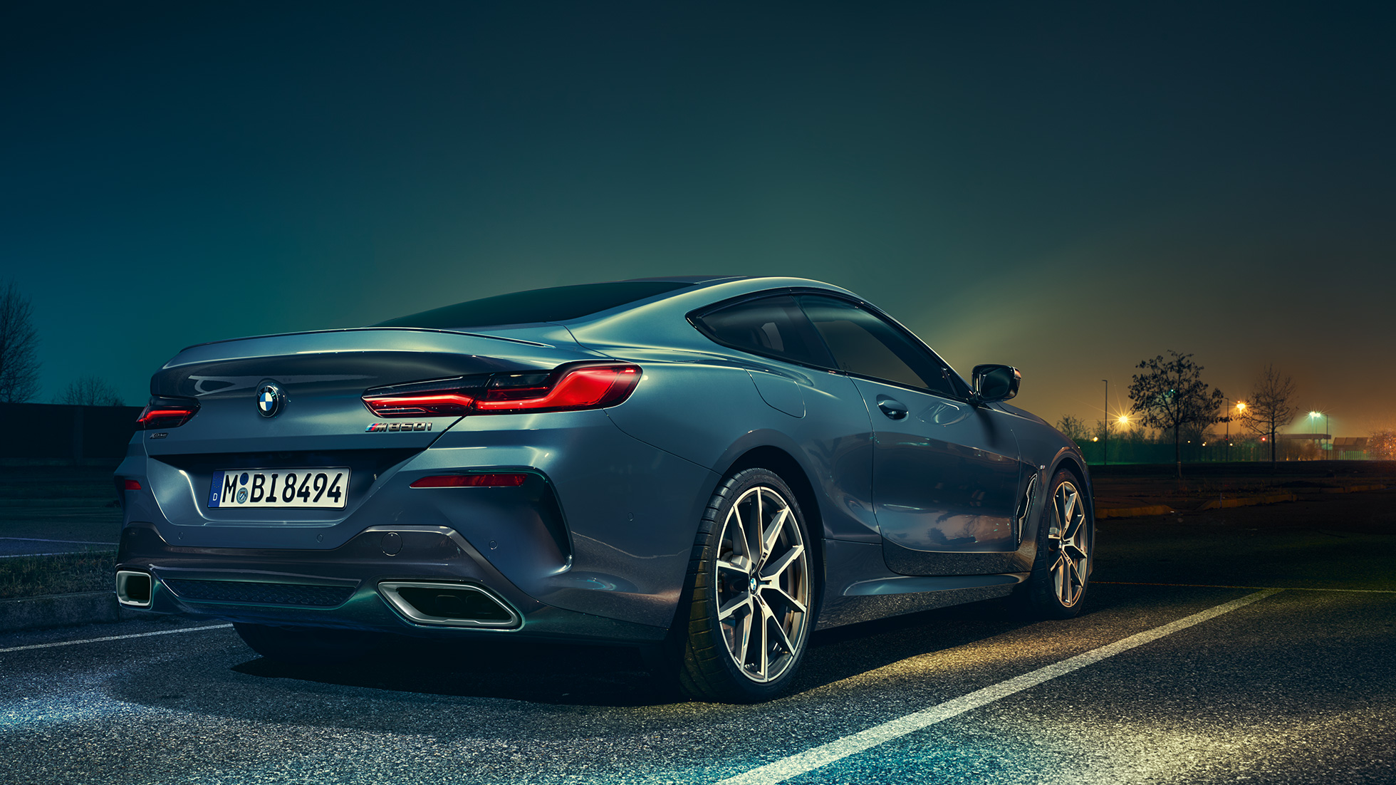 BMW 8. sērijas Coupé, trīs ceturtdaļu aizmugures skats. BMW 8. sērijas Coupé, trīs ceturtdaļu aizmugures skats, stāvošs automobilis uz nakts ainavas fona.