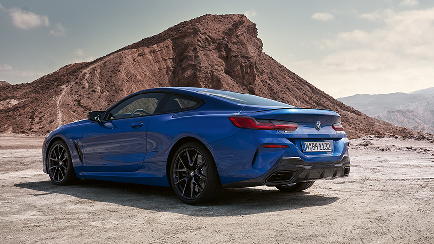 Trīs ceturtdaļu aizmugures skats, BMW 8. sērijas Coupé, M sporta pakotne, G15, LCI, atjaunināts, 2022 BMW 8. sērijas Coupé, M sporta pakotne, G15, LCI, atjaunināts, 2022, metāliska M Portimao Blue krāsa, trīs ceturtdaļu aizmugures skats, stāvošs automobilis uz akmeņu fona