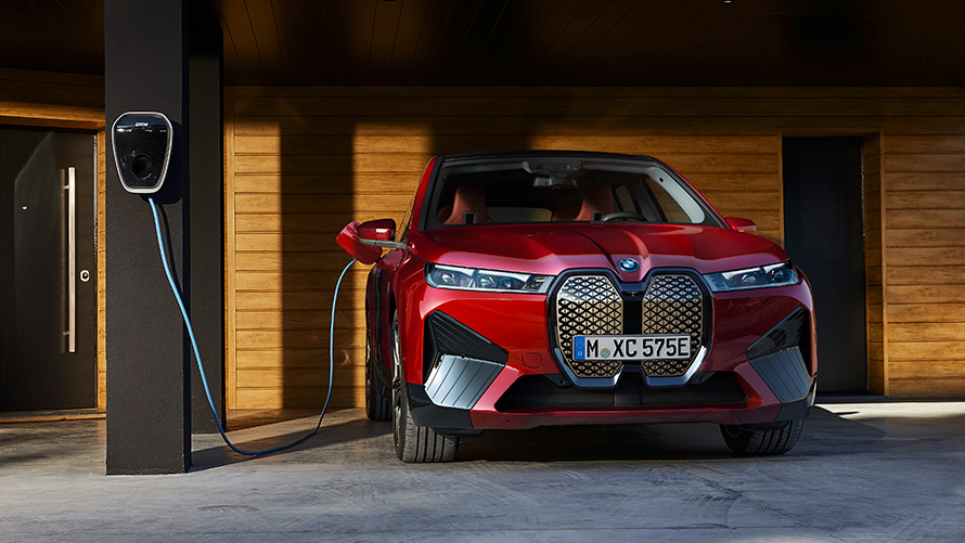 BMW iX i20, 2021, elektrisks SUV, BMW iX xDrive50, uzlāde BMW iX i20, 2021, elektrisks SUV, BMW iX xDrive50, Aventurin Red krāsa, notiekot uzlādei ar BMW Wallbox uzlādi