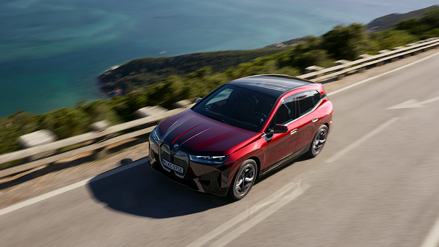 BMW iX i20, 2021, elektrisks SUV, BMW iX xDrive50, Aventurin Red krāsa, braucienā pa ielu, sniegums BMW iX i20, 2021, elektrisks SUV, BMW iX xDrive50, Aventurin Red krāsa, braucienā pa ielu, sniegums