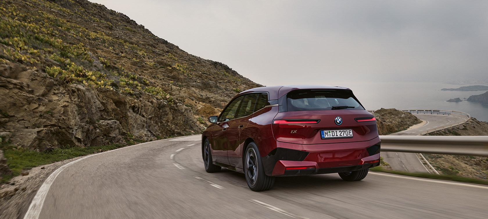 BMW iX i20, 2021, elektrisks SUV, BMW iX xDrive50, braucienā pa piekrastes ceļu BMW iX i20, 2021, elektrisks SUV, BMW iX xDrive50, Aventurin Red krāsa, aizmugures skats, braucienā pa piekrastes ceļu