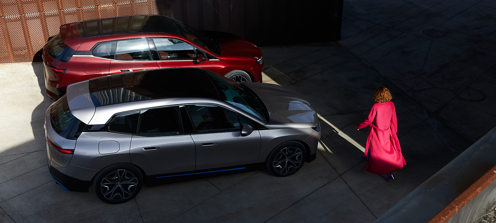 BMW iX, skats no putna lidojuma ar modeli BMW iX, Aventurin Red un Cashmere Silver krāsa, i20, skats no putna lidojuma ar modeli