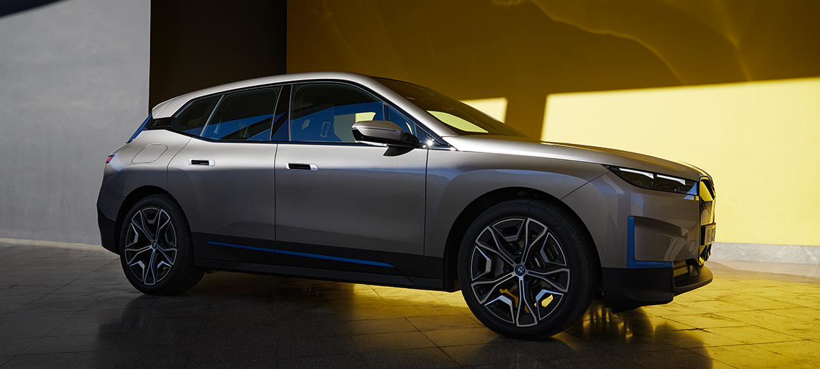 BMW iX, stāvoša automobiļa trīs ceturtdaļu sānskats BMW iX, Cashmere Silver, i20, stāvoša automobiļa trīs ceturtdaļu sānskats
