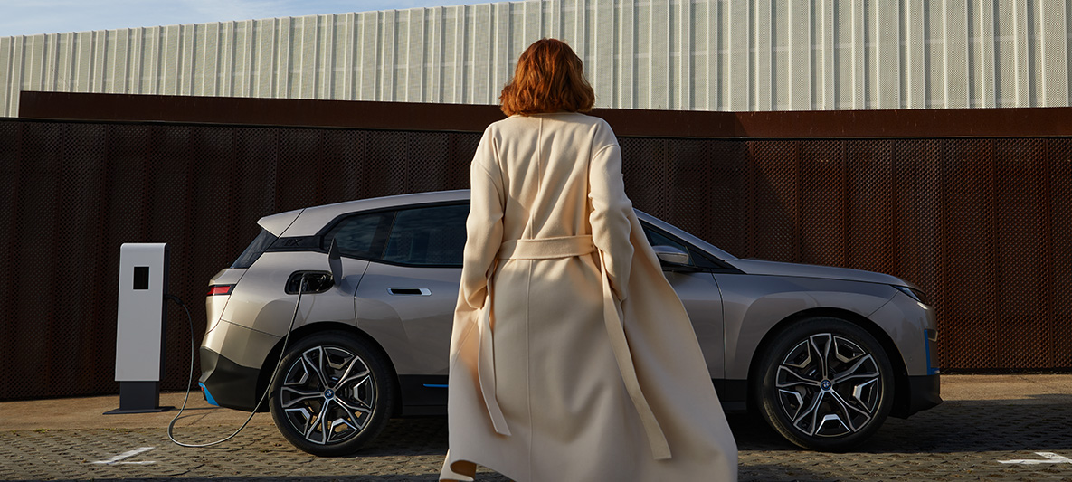 BMW iX, sānskats, stāvošs automobilis BMW iX, Cashmere Silver krāsa, i20, sānskats, stāvošs automobilis ar modeli priekšpusē