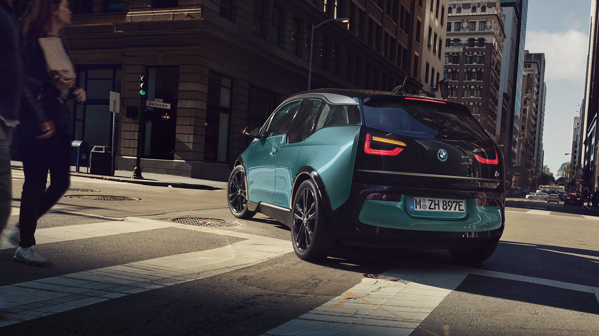 BMW i3 2018, trīs ceturtdaļu skats no aizmugures, braucot BMW i3 I01 2018, Jucaro Beige krāsa ar metālisku Frozen Grey akcentu, trīs ceturtdaļu aizmugures skats, braucot pilsētā