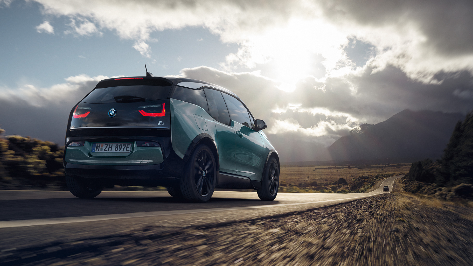 BMW i3 2018, trīs ceturtdaļu skats no aizmugures, braucot pa automaģistrāli BMW i3 I01 2018, Jucaro Beige krāsa ar metālisku Frozen Grey akcentu, trīs ceturtdaļu aizmugures skats, braucot pa automaģistrāli