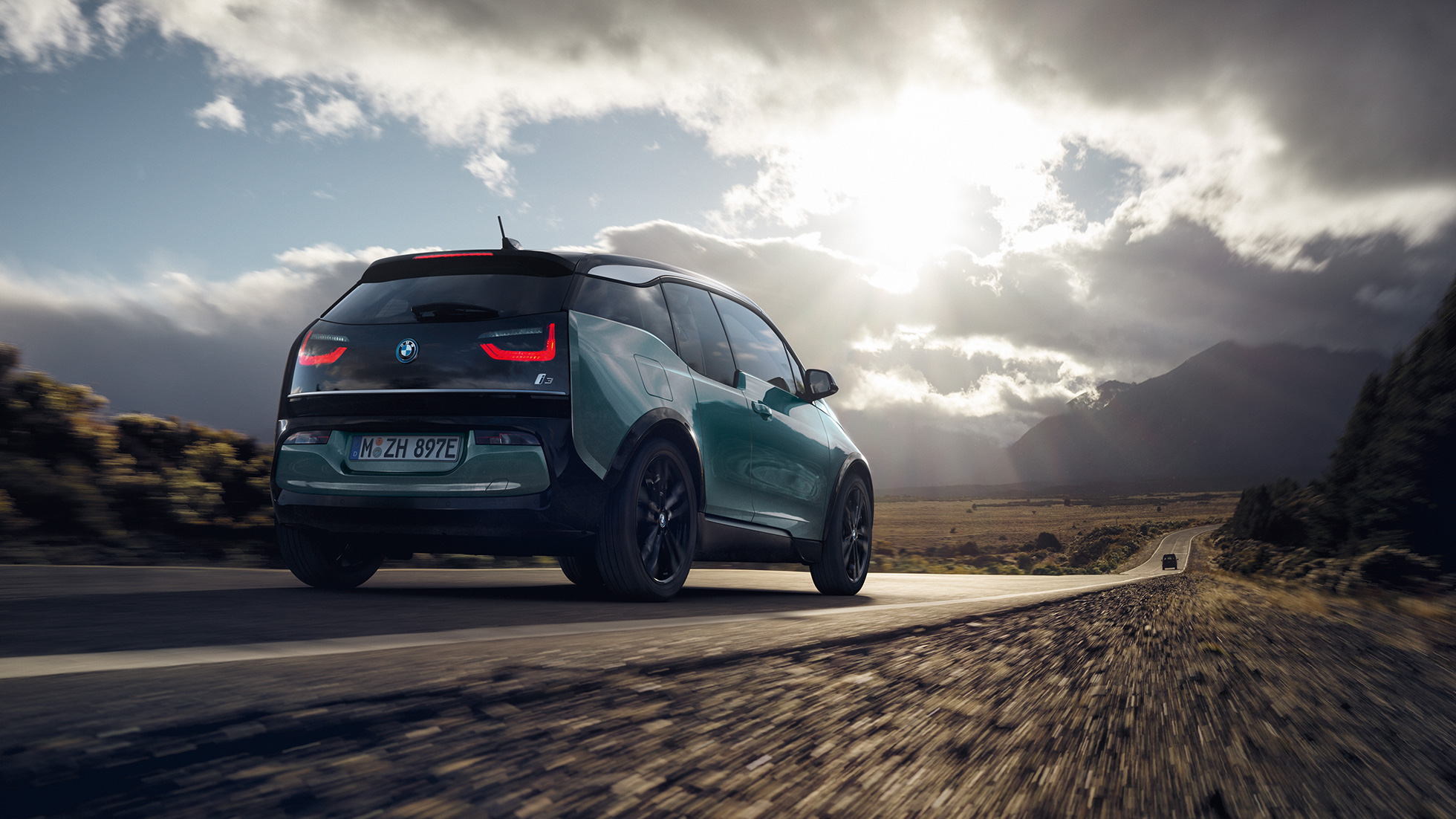 BMW i3 2018, trīs ceturtdaļu skats no aizmugures, braucot pa automaģistrāli BMW i3 I01 2018, Jucaro Beige krāsa ar metālisku Frozen Grey akcentu, trīs ceturtdaļu aizmugures skats, braucot pa automaģistrāli