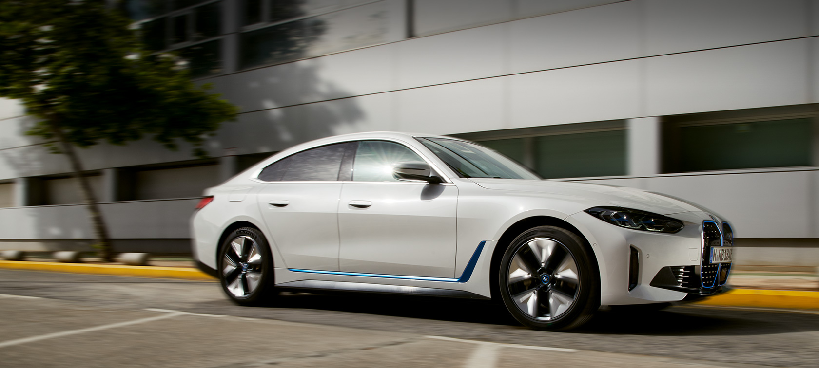 BMW i4, eDrive40, G26, 2021, trīs ceturtdaļu sānskats, stāvošs automobilis uz ēkas fona BMW i4, eDrive40, G26, 2021, trīs ceturtdaļu sānskats, stāvošs automobilis uz ēkas fona