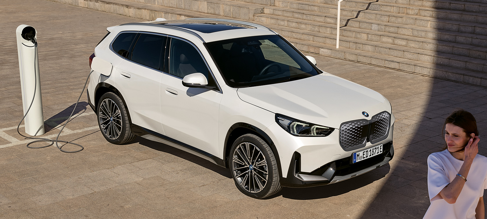 BMW iX1, U11, BEV, sānskats, uzlāde BMW iX1, U11, BEV, 2022, metāliska Mineral White krāsa, divu trešdaļu sānskats, uzlāde, kāpnes