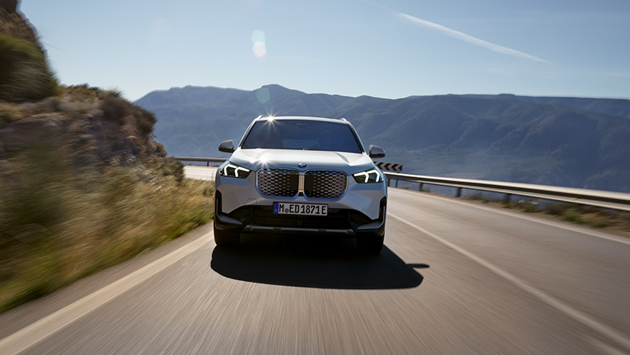 BMW iX1, U11, BEV, 2022, priekšpuses skats BMW iX1 U11 BEV 2022, metāliska Mineral White krāsa, priekšpuses skats, pa kalnu ceļu braucošs automobilis