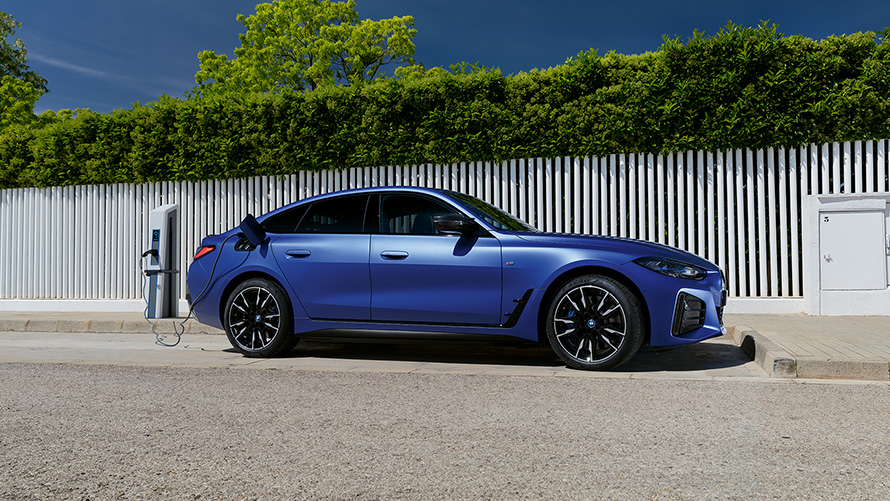 BMW i4 M50, G26, 2021, BMW Individual metāliska Frozen Portimao Blue krāsa, sānskats, savienots ar uzlādes staciju