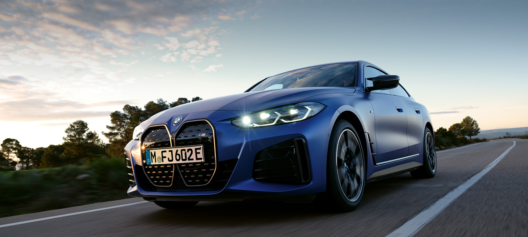 BMW i4 M50, G26, 2021, sānskats, stāvošs automobilis uz akmeņaina apvidus fona BMW i4 M50, G26, 2021, BMW Individual metāliska Frozen Portimao Blue krāsa, sānskats, stāvošs automobilis uz akmeņaina apvidus fona