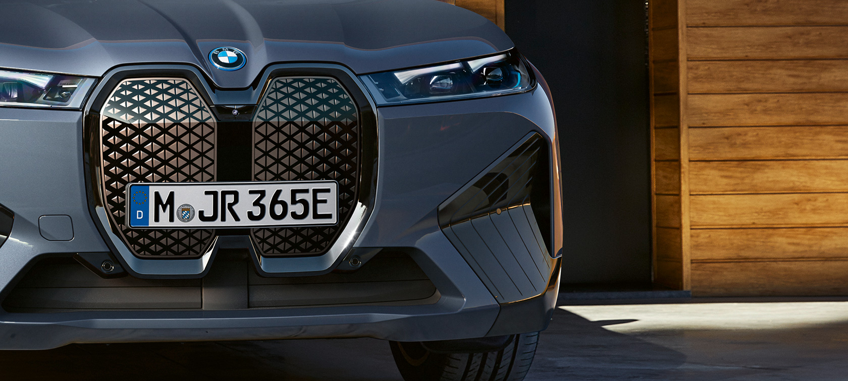 BMW iX M60 i20, 2022, elektrisks SUV, BMW Individual metāliska Storm Bay krāsa, tuvplāns, priekšdaļa ar vertikālu BMW elipsveida režģi