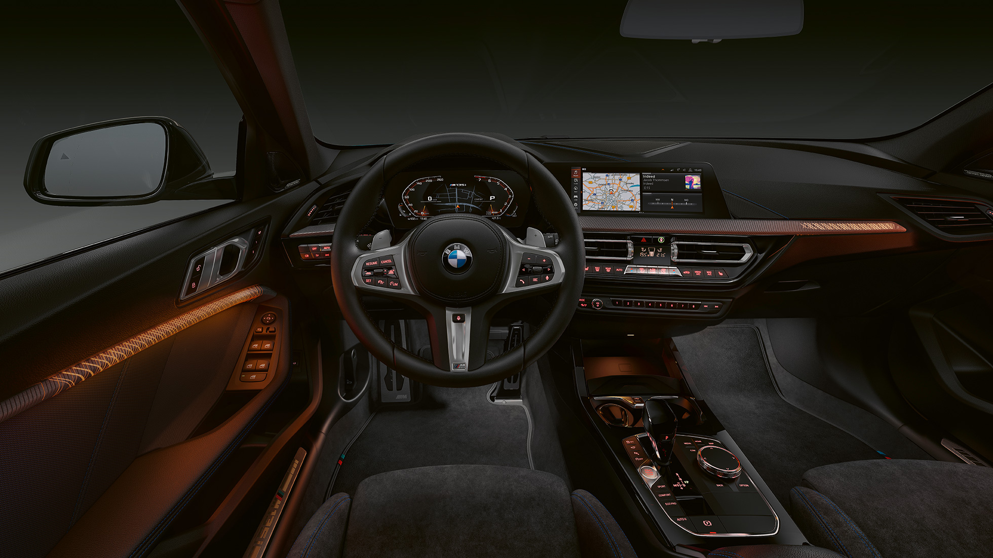 BMW M135i xDrive, kokpits. BMW M135i xDrive augstākās klases salons ar izgaismotiem salona apdares elementiem.