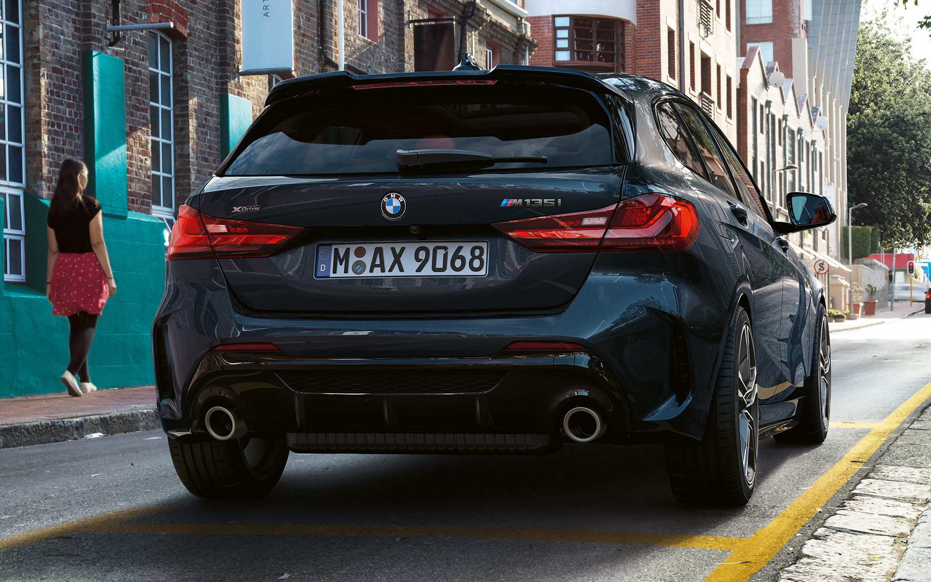 BMW M135i xDrive (F40) metāliskā Black Sapphire krāsā, novietots stāvvietā skatā no aizmugures
