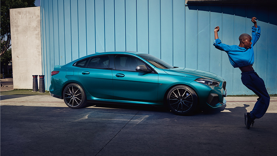 BMW M235i xDrive Gran Coupé F44, sānskats, ar sievieti priekšplānā BMW M235i xDrive Gran Coupé F44, metāliska Snapper Rocks Blue krāsa, sānskats, ar sievieti priekšplānā