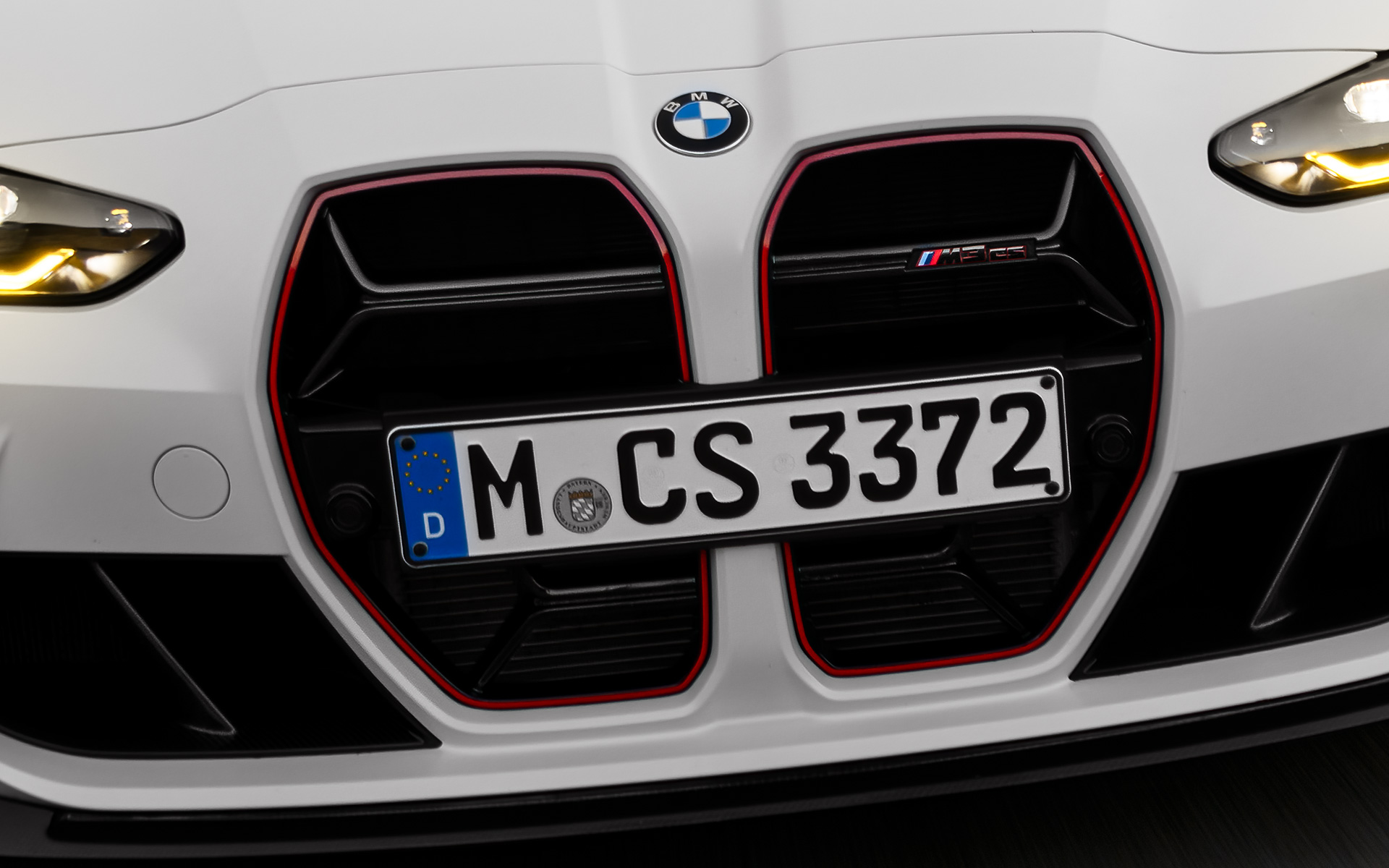 CS raksturīgais elipsveida režģis Black un Red krāsā ar raksturīgo modeļa iezīmi, BMW M3 CS, G80 BMW M3 CS, G80, CS raksturīgais elipsveida režģis Black un Red krāsā ar raksturīgo modeļa iezīmi, priekšpuses skats, braucienā