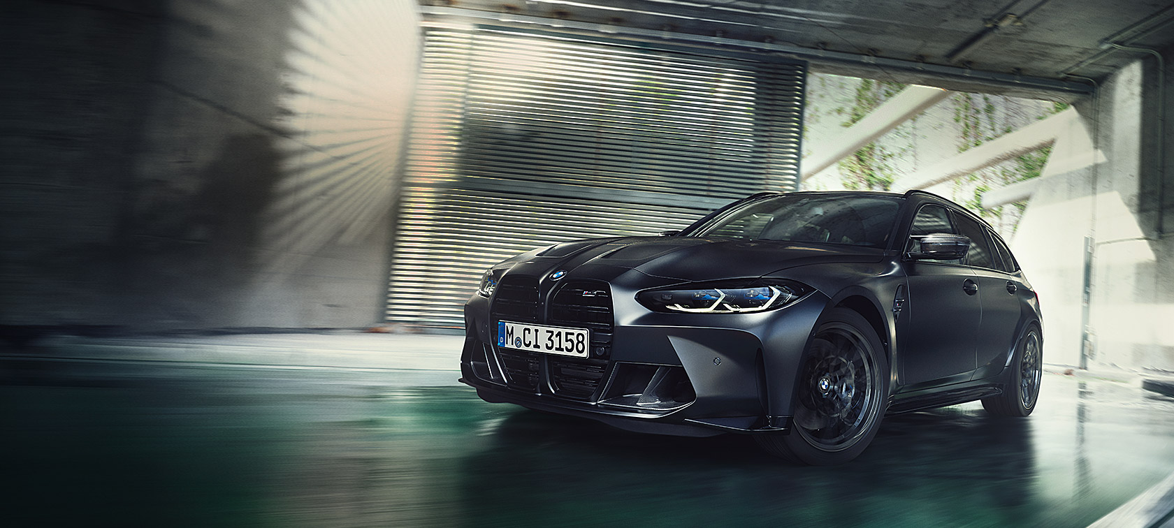 BMW M3 Competition Touring, G81, BMW Individual metāliska Frozen Black krāsa, trīs ceturtdaļu priekšpuses skats, braucienā
