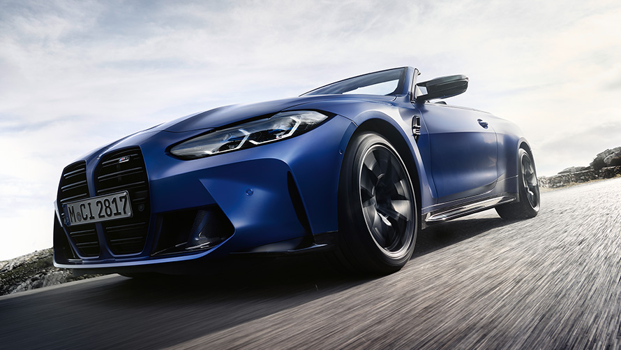 BMW M4 M Competition Cabrio ar M xDrive, G83, 2021, priekšpuses skats ar dubultu elipsveida režģi BMW M4 Competition Cabrio ar M xDrive G83, 2021, BMW Individual metāliska Frozen Portimao Blue krāsa, priekšpuse, elipsveida režģis, uzņēmums no zema leņķa